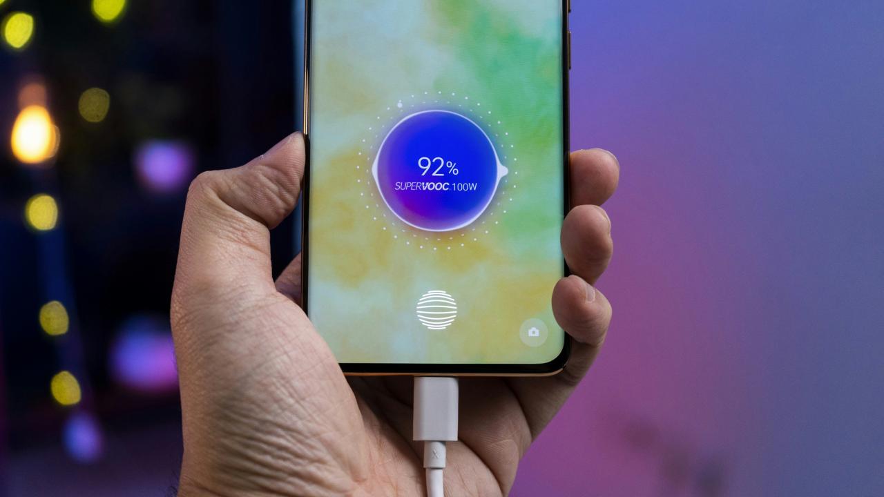 A cell phone with a charger in their hand